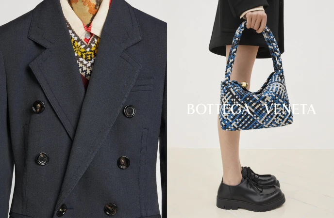 Fashion editorial shot of a double-breasted navy blazer with a patterned sweater and woman carrying a blue woven purse with black loafers.