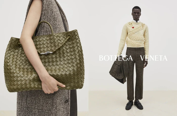 Close-up of a green woven leather tote bag alongside a model standing in a cream knit snake sweater for Bottega Veneta.
