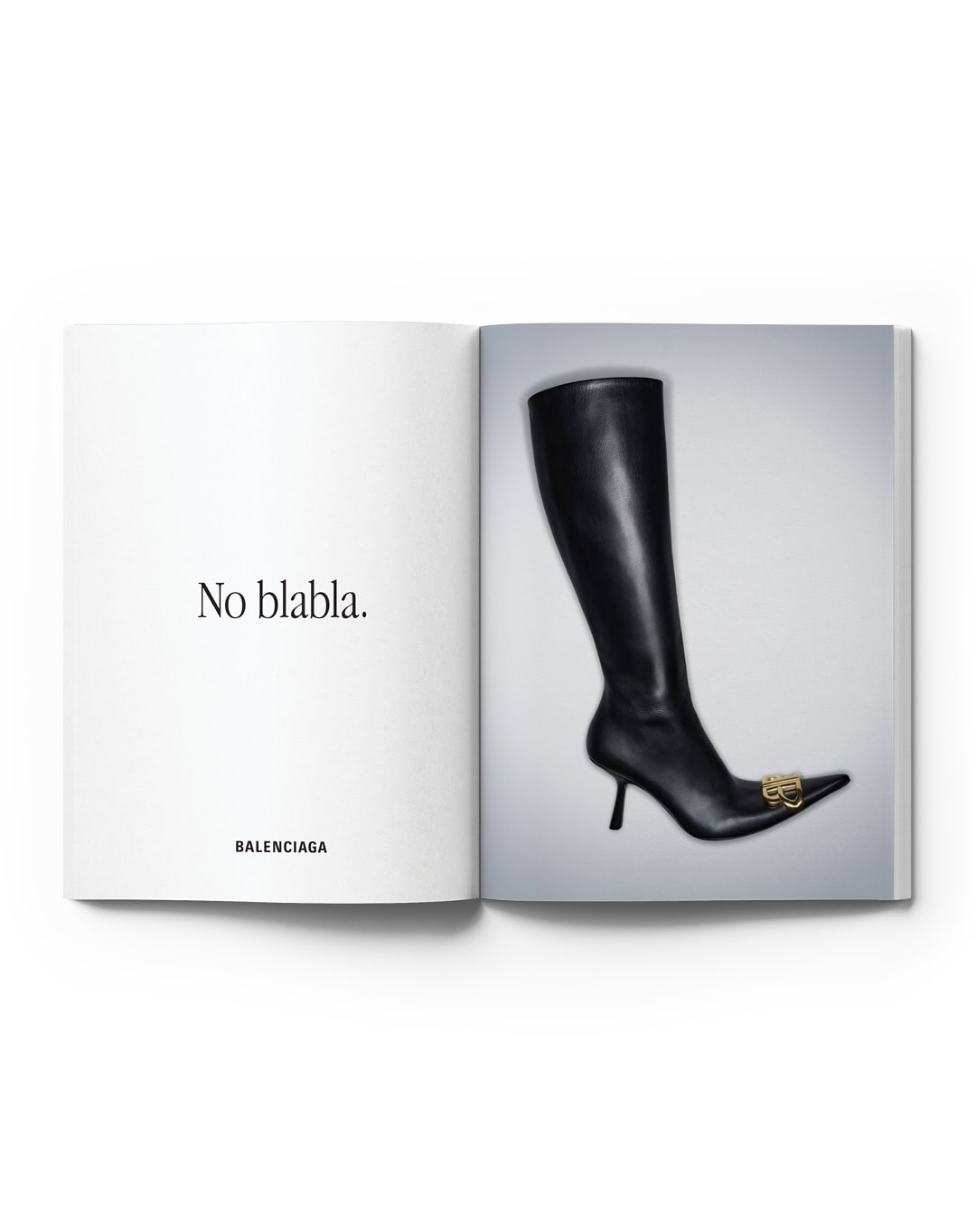 Open magazine featuring a black leather knee-high heeled boot with gold logo on a white background. Fashion editorial photography.