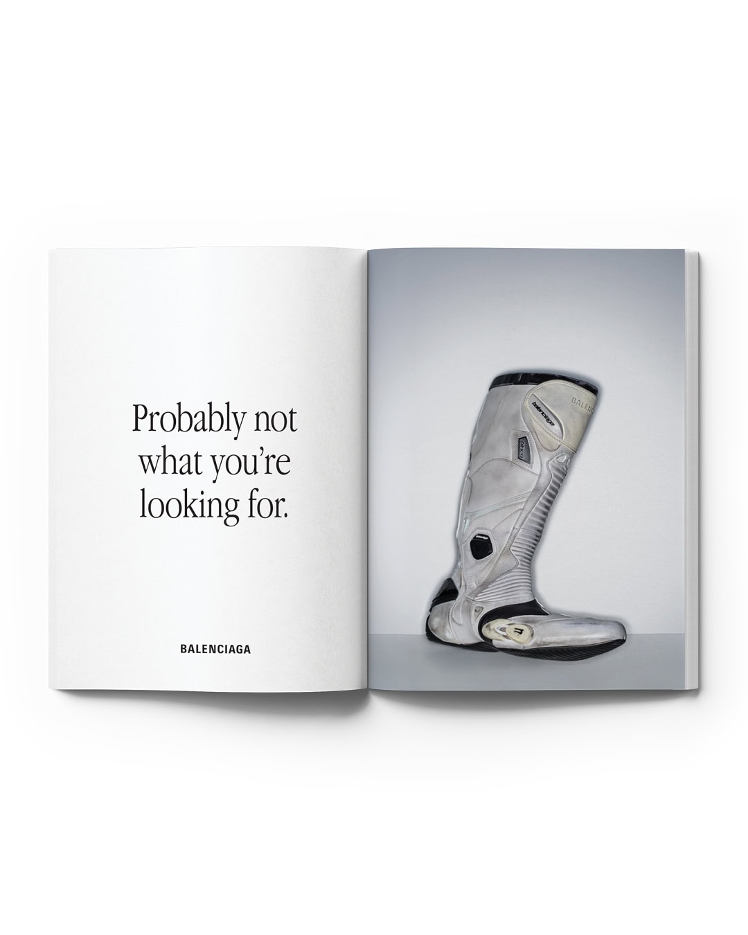 Open book with a Balenciaga advertisement featuring a grey boot on a white background with minimalist text on the opposing page.