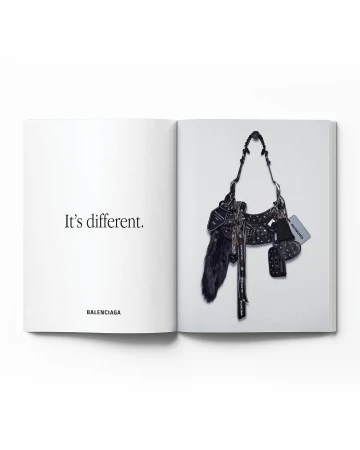 Open magazine featuring a Balenciaga purse and the text 'It's different.' The purse is detailed with black, white, and silver accents.