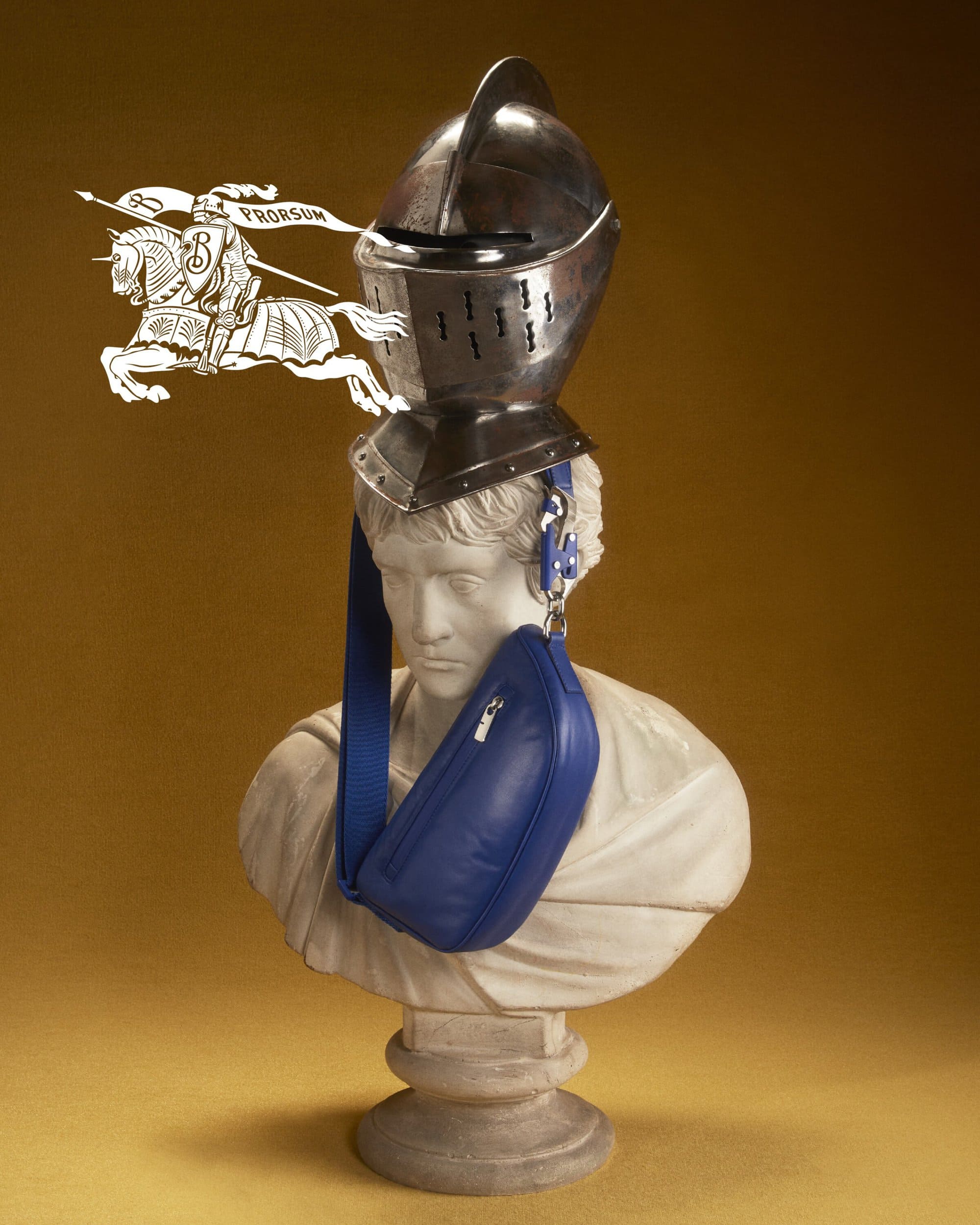 Bust with a medieval helmet and a blue bag in a studio setting with warm color grading and a logo of a knight on a horse.