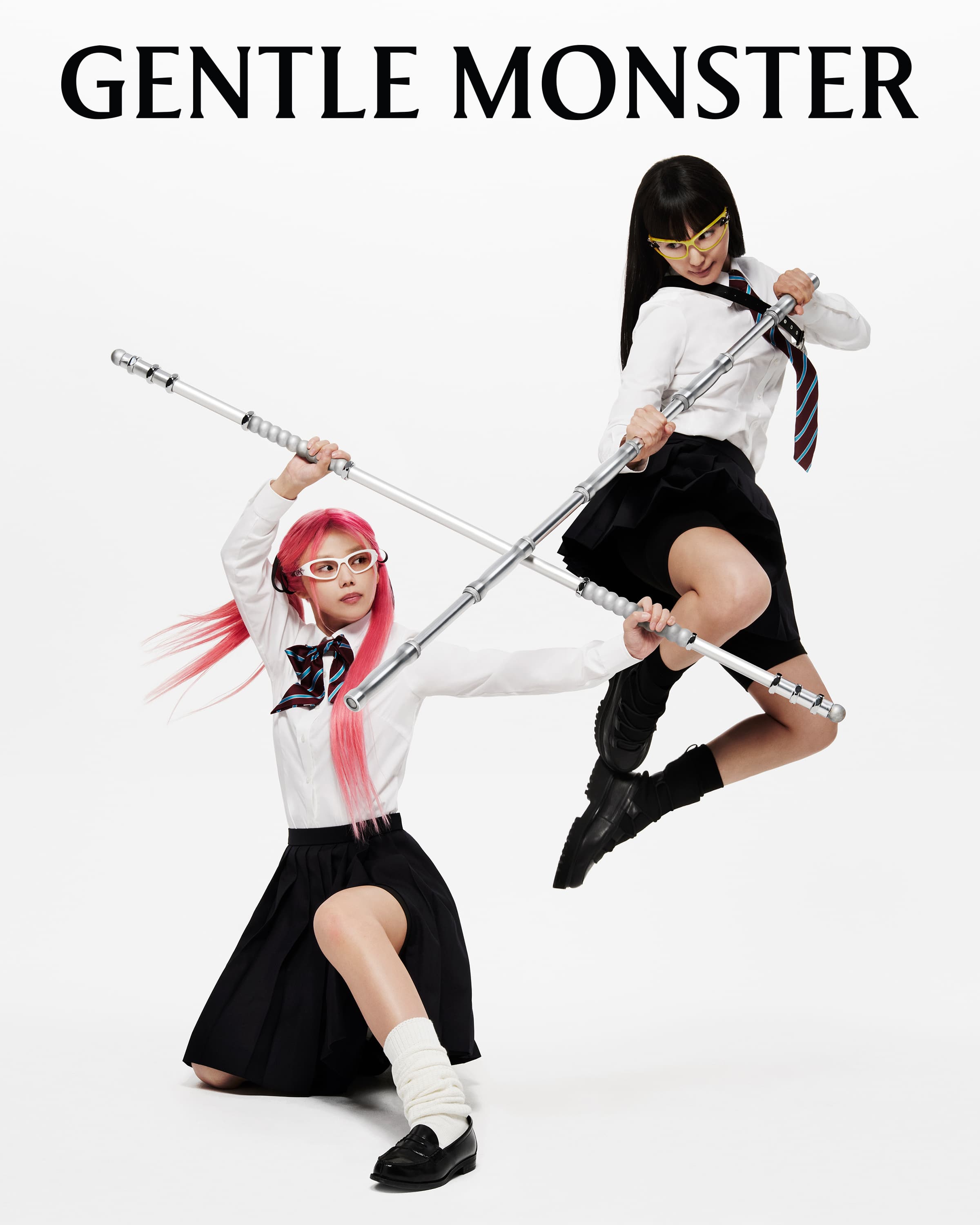 Two models wearing school uniforms and sunglasses pose dynamically with metallic rods against a bright white background for a fashion brand ad.