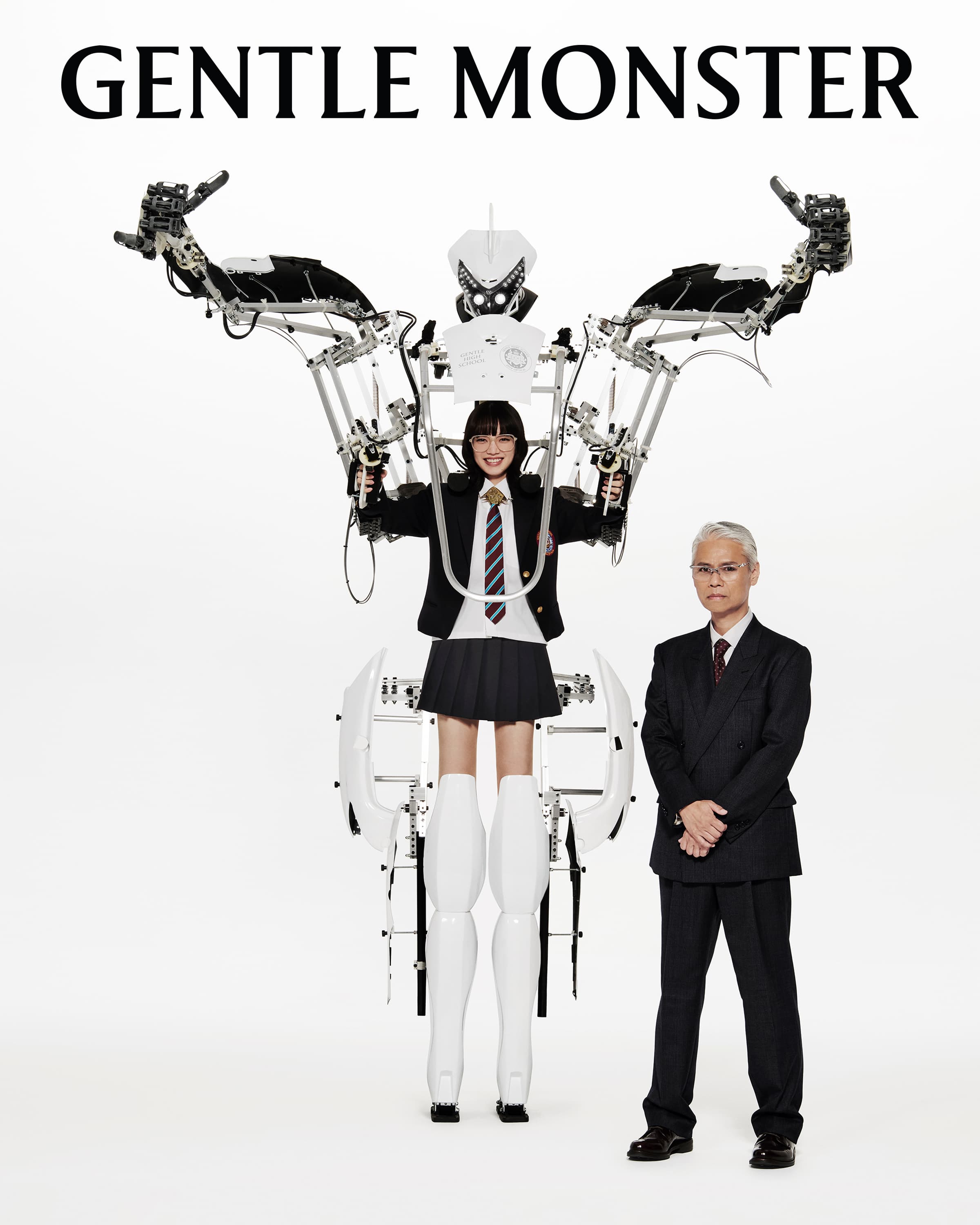 Gentle Monster campaign image featuring an adult woman and man standing beside a robotic exoskeleton on a clean white background.