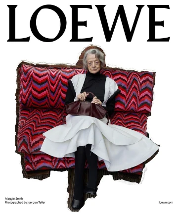 Maggie Smith sits on a vibrant zigzag-patterned couch, wearing a white layered skirt and black top while holding a dark leather Loewe bag.