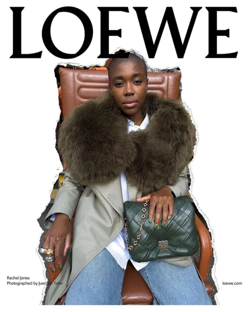 Woman in a trench coat and fur stole seated with a leather handbag, posing for a Loewe fashion brand ad.