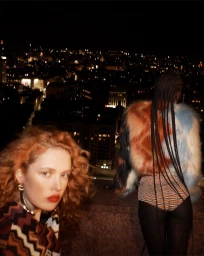 Two models on a rooftop at night overlooking a glittering city skyline in a Missoni Fall 2023 ad campaign image.