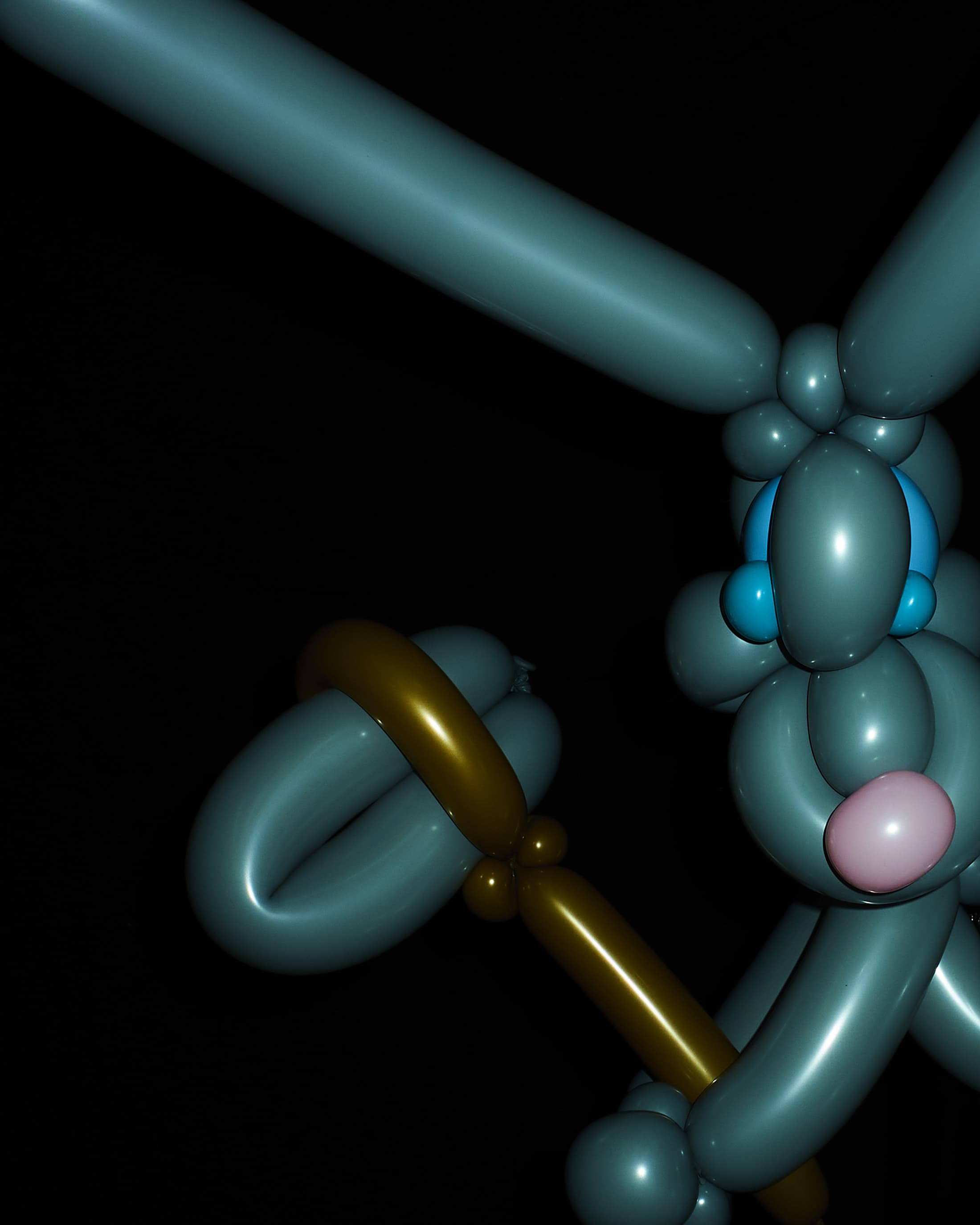 Grey balloon animal sculpture of a rabbit holding a staff with a dark background, creating a whimsical and artistic visual.