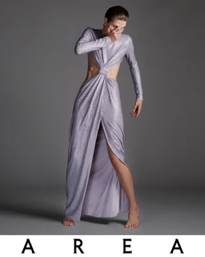 Sylvia Anderson wearing a lilac sequin cut-out maxi dress with long sleeves against a grey studio backdrop for Area.