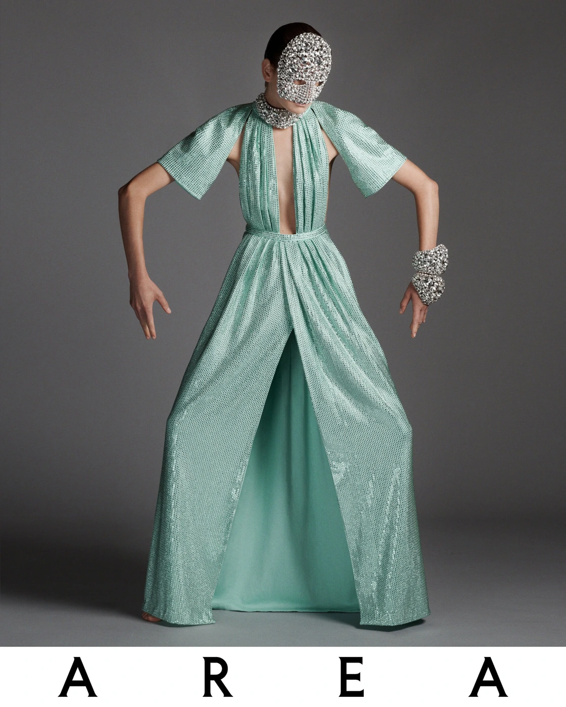 Model Sylvia Anderson wearing a sparkling mint green sequin gown and crystal face mask in Area Holiday 2023 campaign.