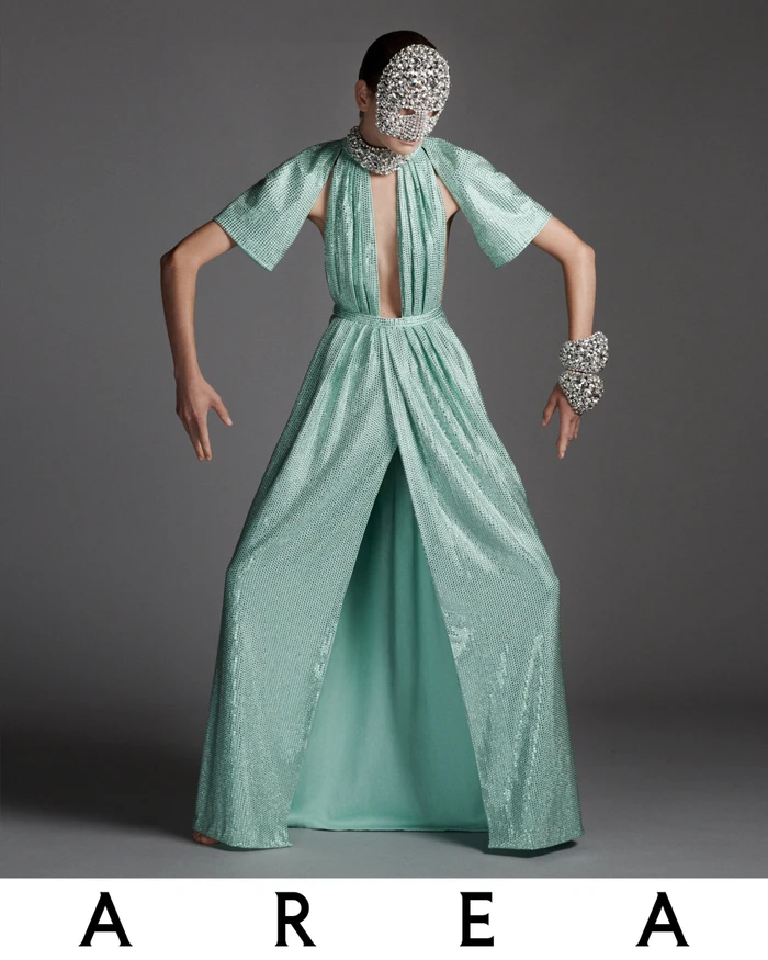 Model Sylvia Anderson wearing a sparkling mint green sequin gown and crystal face mask in Area Holiday 2023 campaign.
