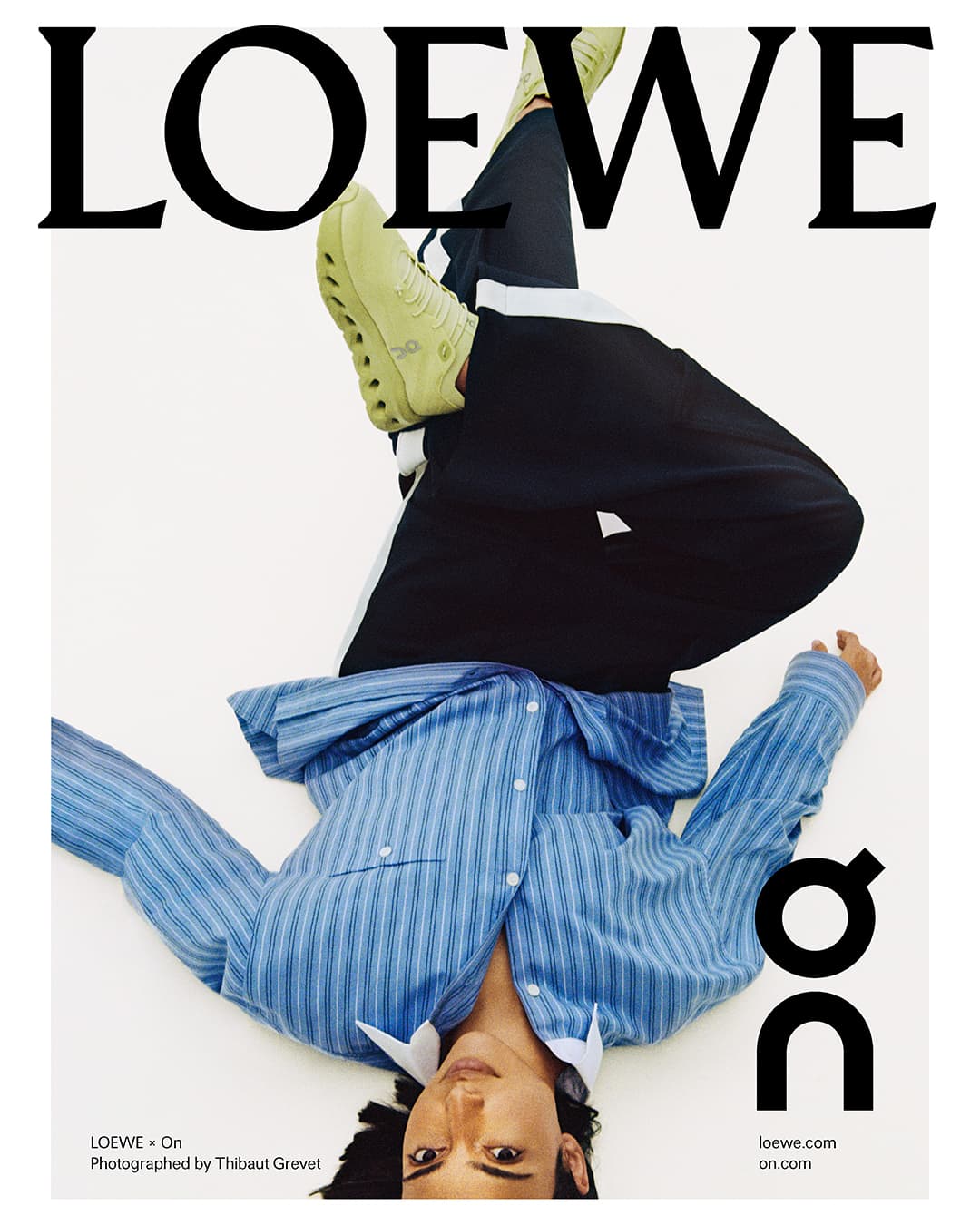Upside-down fashion shot: A person in a blue striped shirt and black pants, paired with yellow sneakers, against a clean white backdrop.