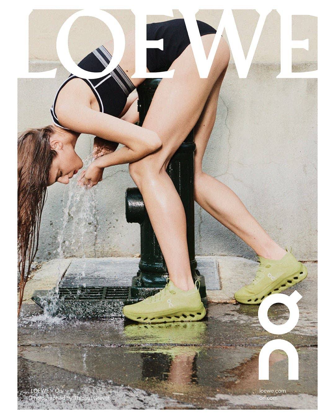 Athletic woman in activewear cools down at a city water hydrant. She is wearing running shoes and a sports top with moisture on her skin.