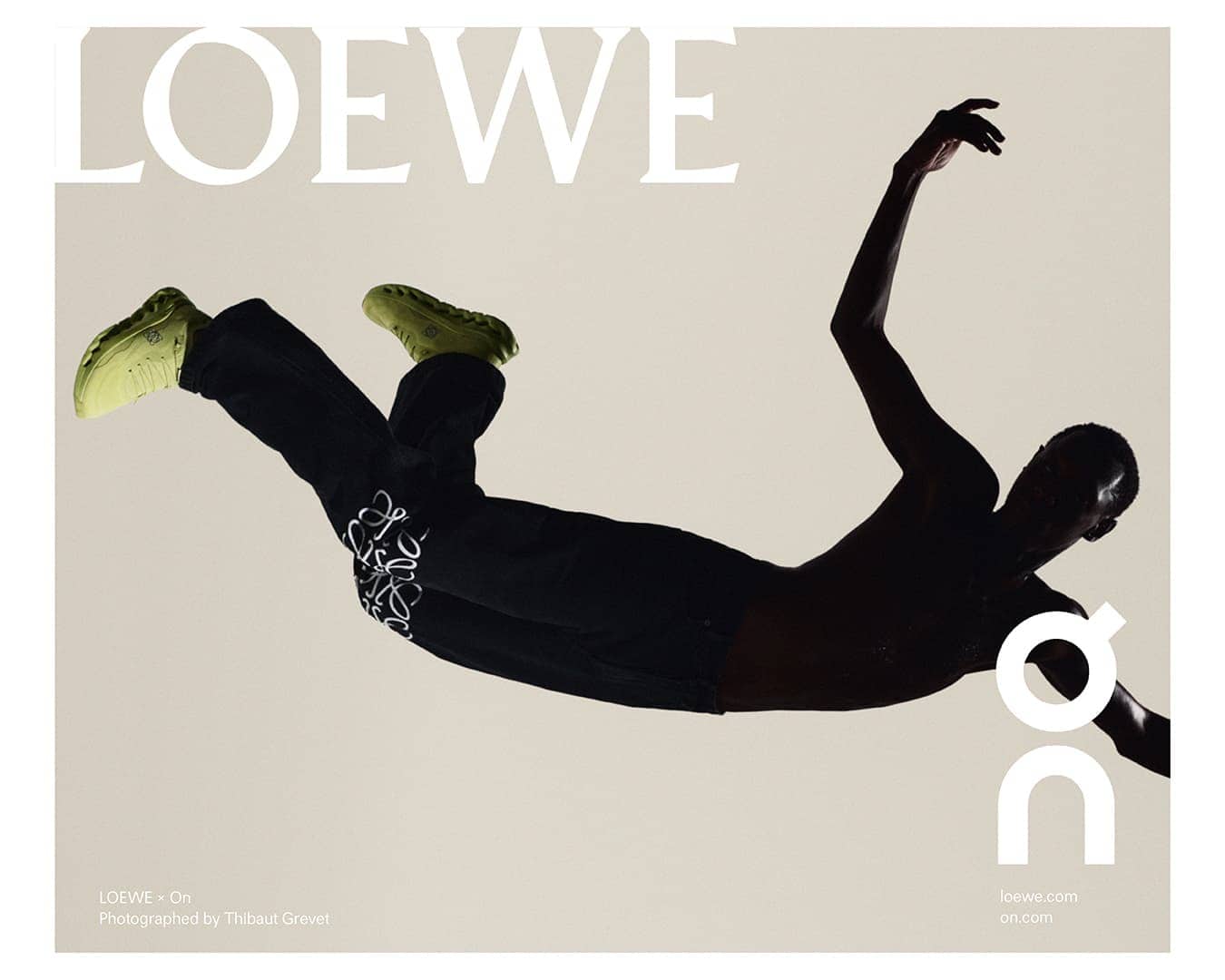Fashion editorial shot featuring a person mid-air wearing black pants with white accents and green shoes, against a gradient background.