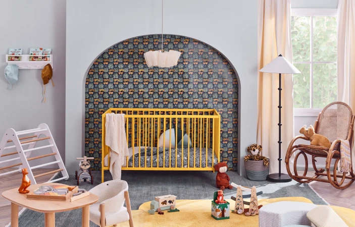 Bright yellow crib and wooden toys in a playful baby nursery, lit by natural light from a window, creates a cheerful atmosphere.