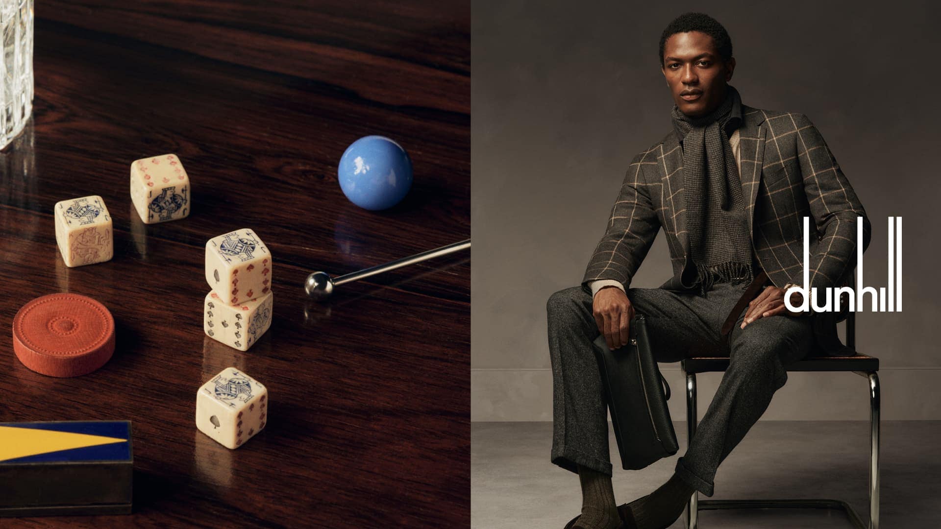 A fashionable man in a suit sits next to dice and a ball on a wood table, promoting Dunhill, a brand specializing in tailored suits.