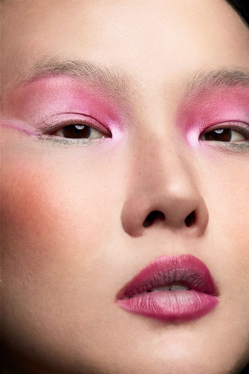 Close-up portrait of an Asian woman with pink eyeshadow and magenta lipstick, face centered, showcasing beauty makeup.