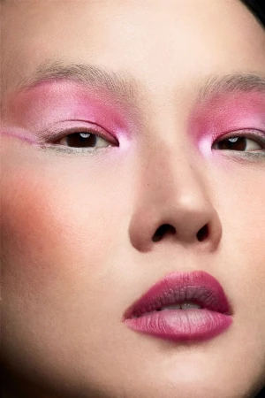 Close-up portrait of an Asian woman with pink eyeshadow and magenta lipstick, face centered, showcasing beauty makeup.