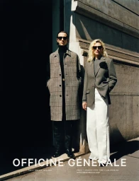 Man and woman wearing sunglasses and tailored clothing standing outdoors against a stone building for Officine Generale Fall 2023 campaign.