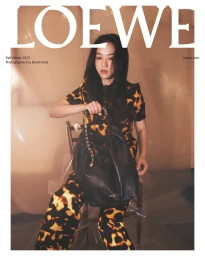 Tang Wei wearing a tortoiseshell print outfit while holding a black leather shoulder bag for Loewe Fall Winter 2023 campaign.