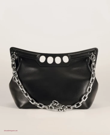 Black leather shoulder bag with a silver chain strap and four white circles, set against a light neutral studio background.