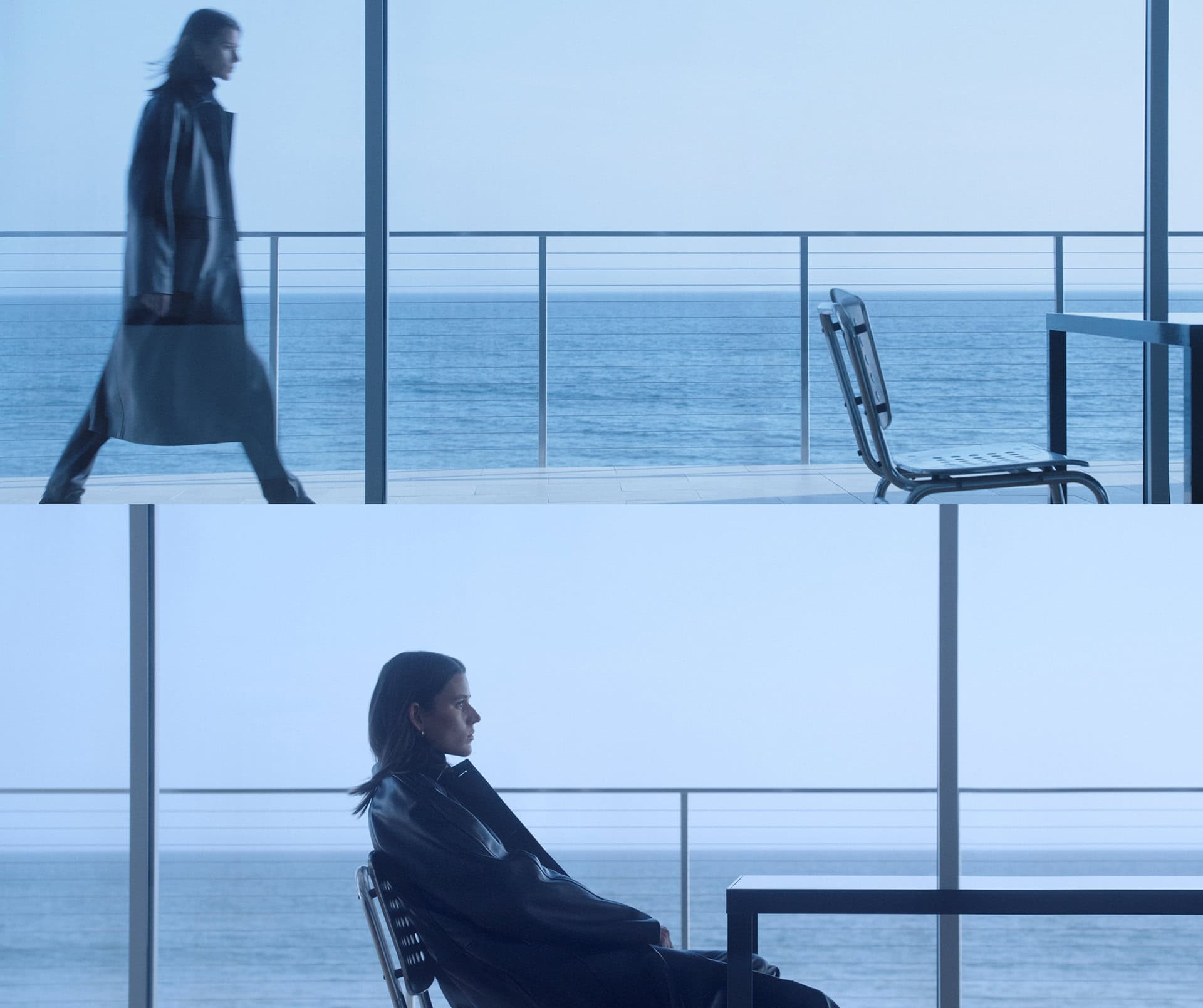 A woman in a black coat walks along a modern balcony overlooking the ocean, while another woman sits in a chair in the foreground.