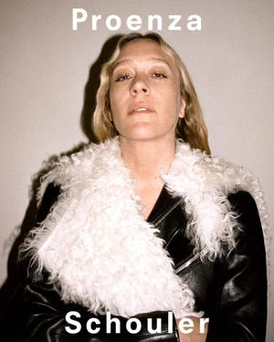 Chloë Sevigny wearing a black leather jacket with a textured white shearling collar against a neutral studio backdrop.