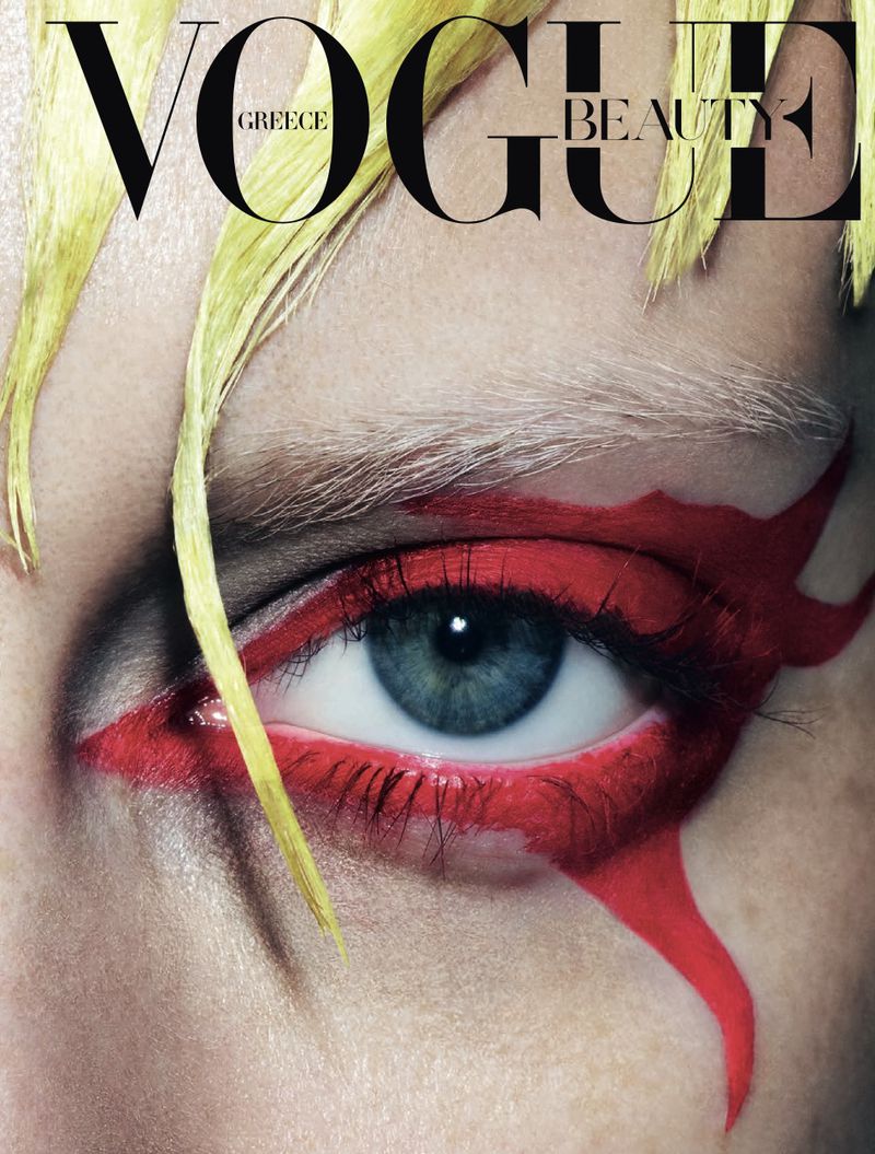 Close-up of a woman's eye with dramatic red makeup, complemented by Vogue Greece Beauty masthead, highlighting beauty and editorial style.