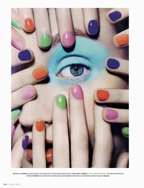 Close-up studio shot of a woman's eye surrounded by colorful manicured fingers creating a frame, fashion, and beauty concept.