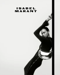 Irina Shayk leaning against a black pillar wearing a black dress and a metallic silver shoulder bag for Isabel Marant.