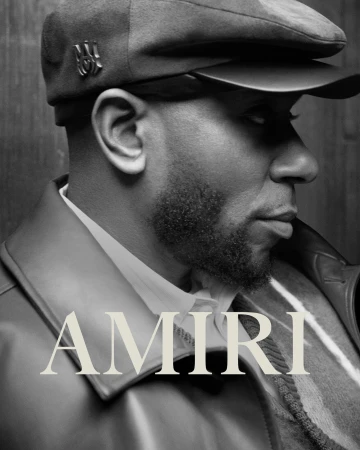 Black and white profile portrait of Yasiin Bey wearing a flat cap and leather jacket for Amiri Fall 2023