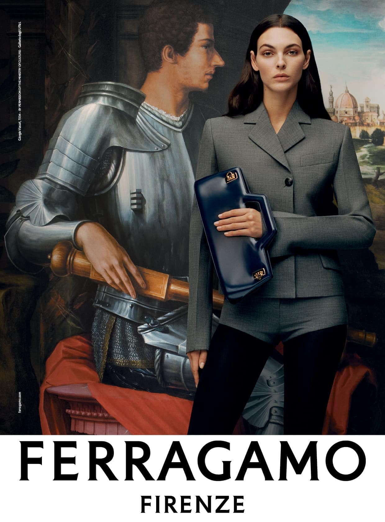 A model in a grey suit stands in front of a painting holding a blue handbag, for a Ferragamo fashion advertisement, Florence, Italy.