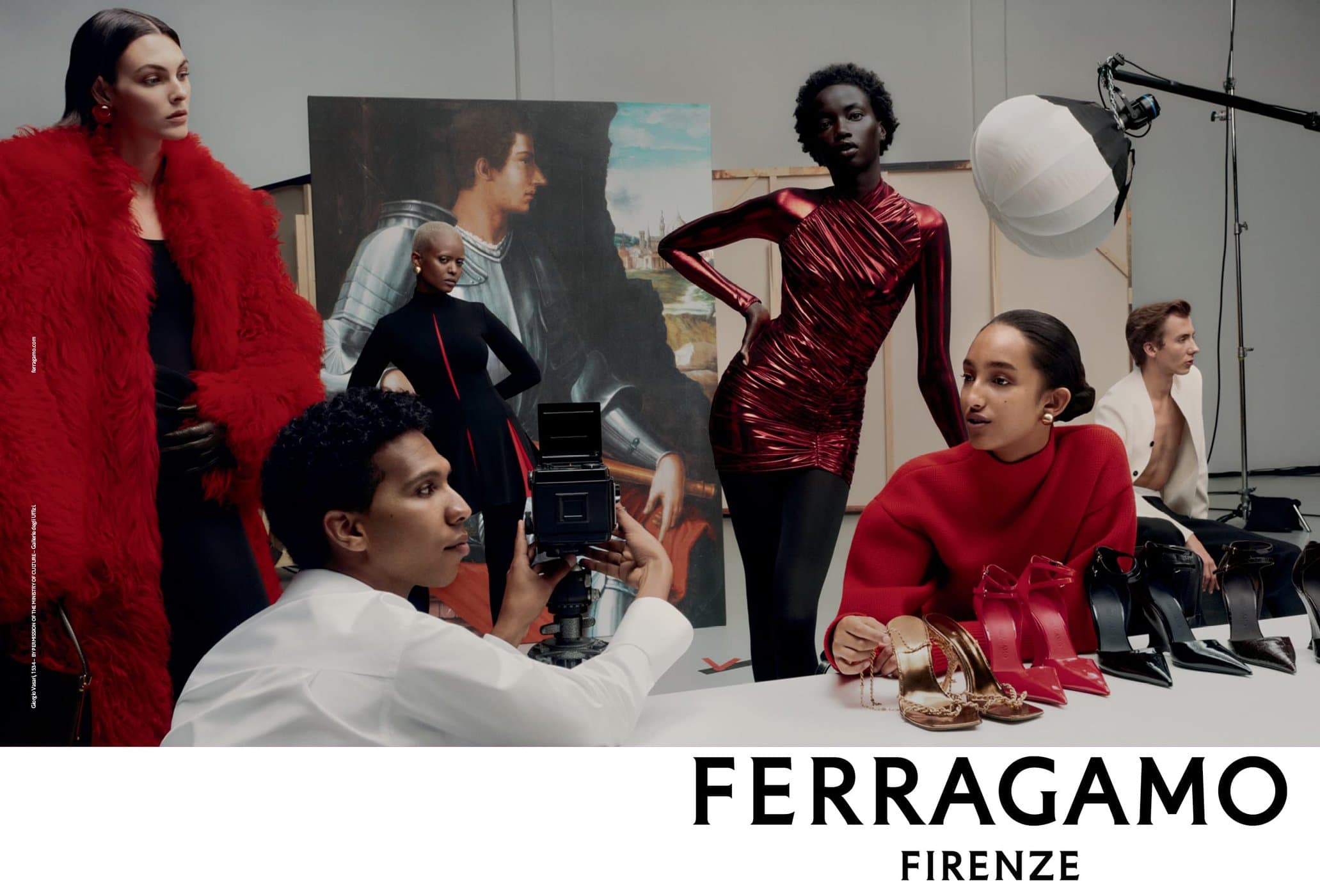 Fashion editorial featuring diverse models in a studio with red and metallic clothing, shoes, and a photographer with vintage camera equipment.