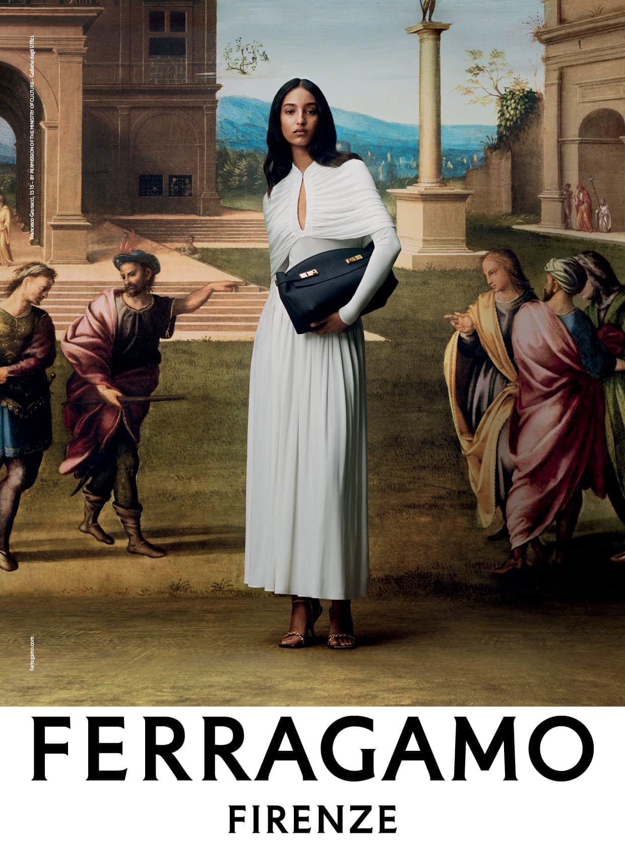 Elegant brunette woman in a white dress holds a black handbag in front of a Renaissance-style painting, fashion advertisement.