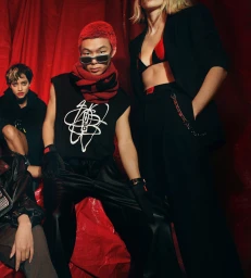 Group of models posing against a striking red draped backdrop for the HUGO Fall 2023 ad campaign by Stuart Winecoff.