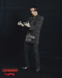 Model Søren Müller poses in a grey 'Scottish Basic' suit with claw-tipped fingers for the Charles Jeffrey Loverboy campaign.