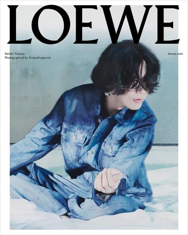 Fashion magazine cover featuring Kerashi Yonezu in blue denim jacket and jeans, posing on a bed against a muted background.