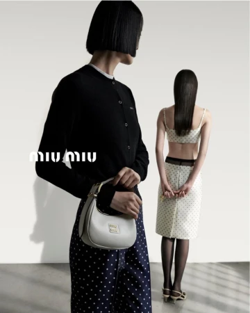 A Miu Miu fashion shot showcases two Asian women wearing black and white polka dot print skirt and cardigan with a white leather purse.