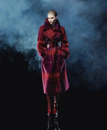 Model Ida Heiner in a textured red coat against a smoky background for Alberta Ferretti fall campaign