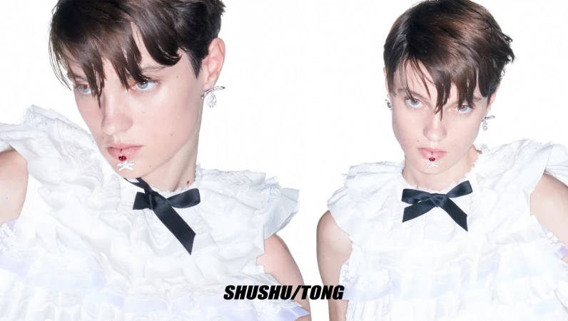 Two portraits of a young adult with short dark hair wearing a white ruffled dress with a black bow and lip jewelry against a white background.