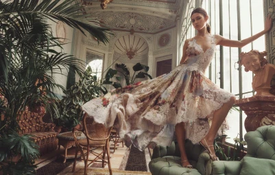 Model Vivienne Rohner in a billowing floral lace dress posing dynamically on an armchair inside an ornate Parisian conservatory.