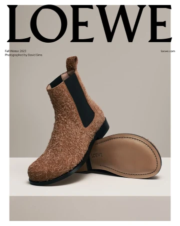 Loewe fall/winter 2023 fashion ad featuring a brown suede Chelsea boot with a black elastic side panel on a cream surface.