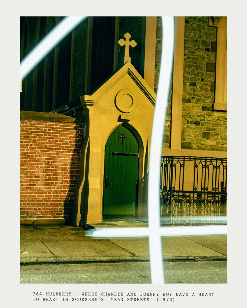 Exterior night view of a chapel door with a cross on top, set in a brick building, illuminated by artificial light with geometric shapes.