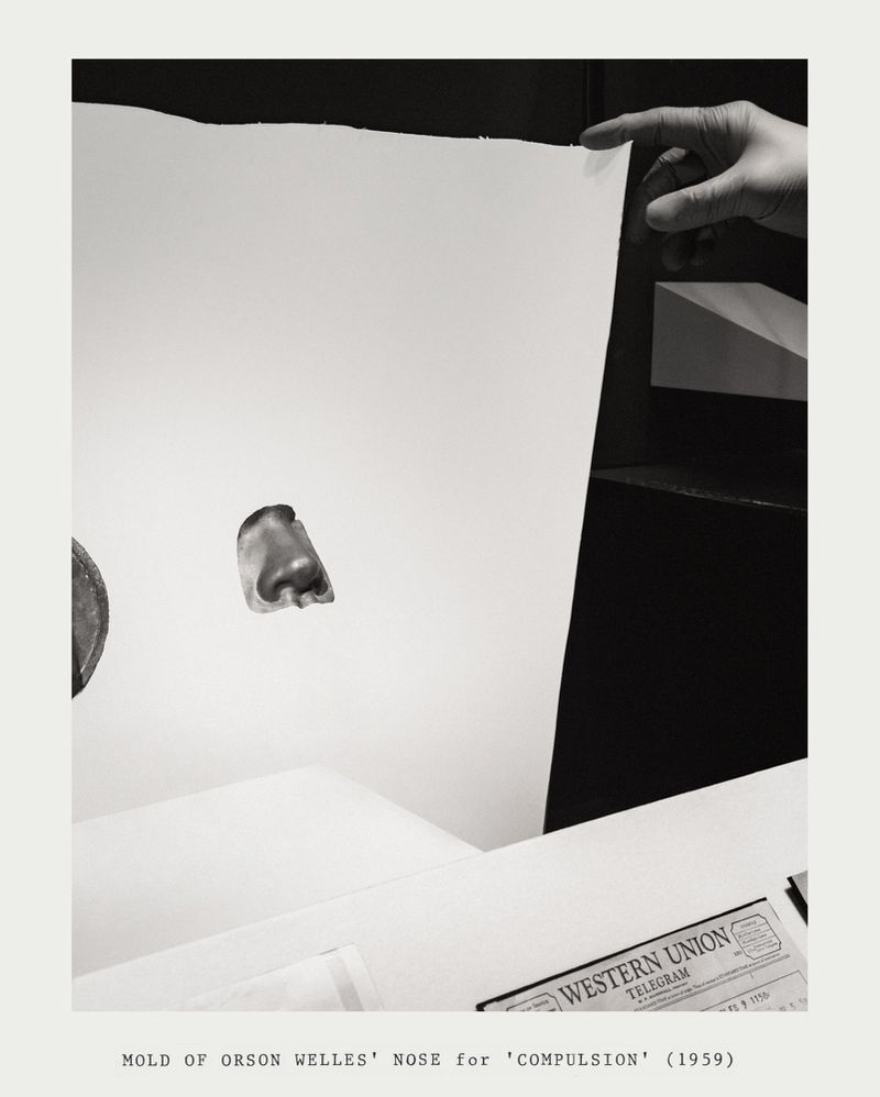A hand holds up a blank white board with a nose mold in front and Western Union telegram in black and white.