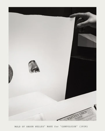 A hand holds up a blank white board with a nose mold in front and Western Union telegram in black and white.