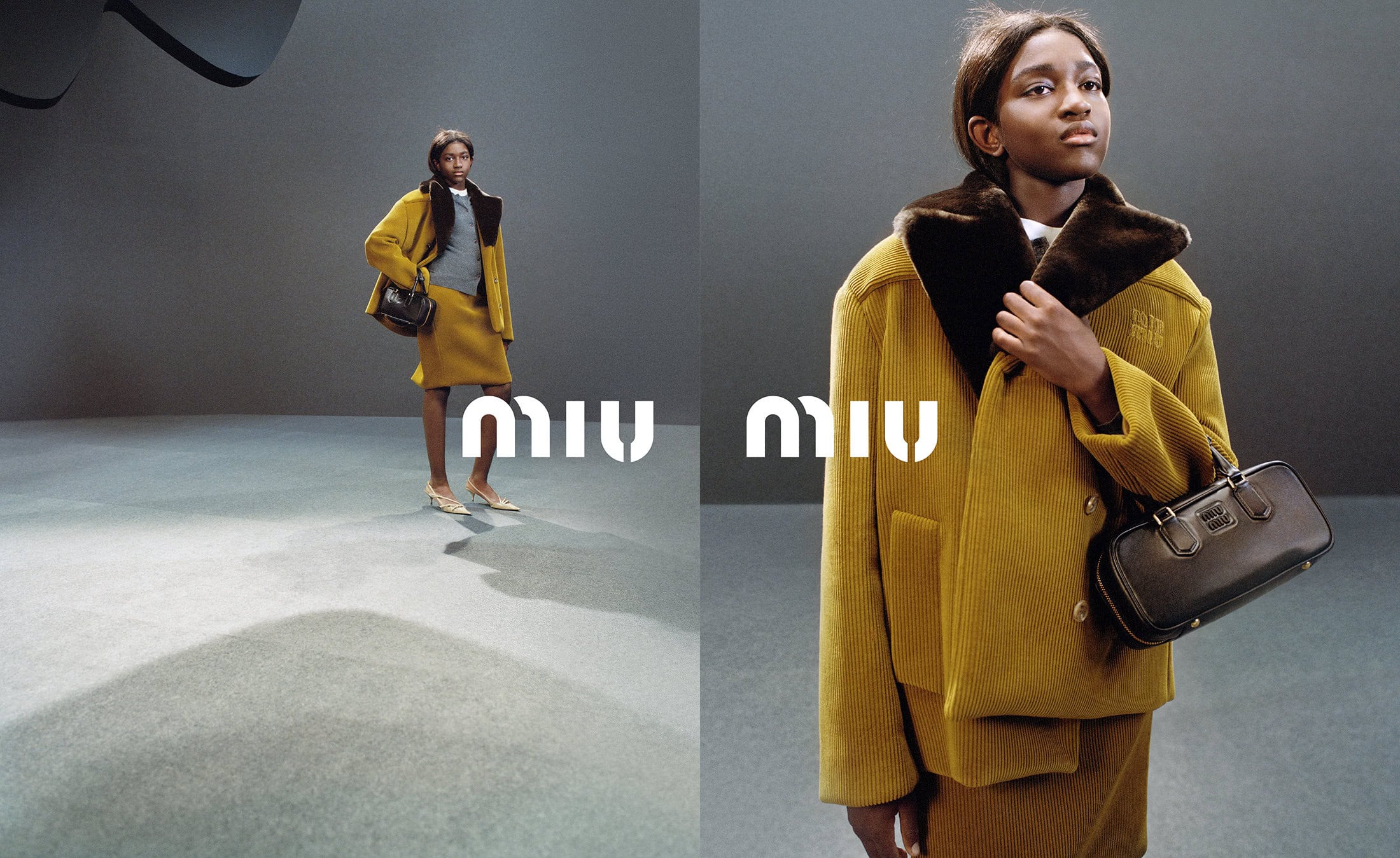 Fashion shot featuring a dark-skinned adult female model in a gold corduroy skirt suit, holding a black handbag, against a grey background.