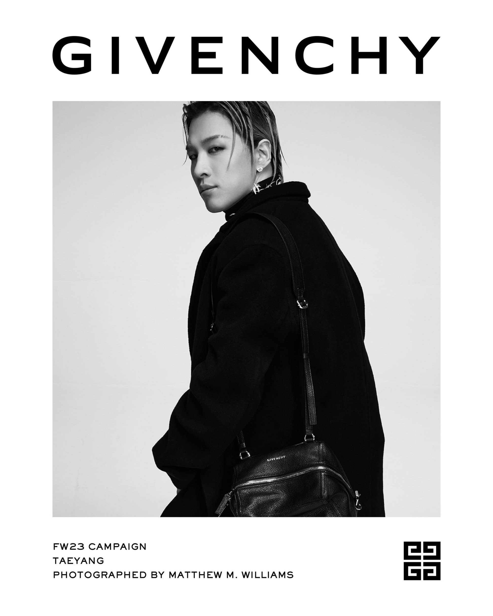 Taeyang poses in a black Givenchy coat and matching bag against a white backdrop for the FW23 campaign, photographed by Matthew M. Williams.