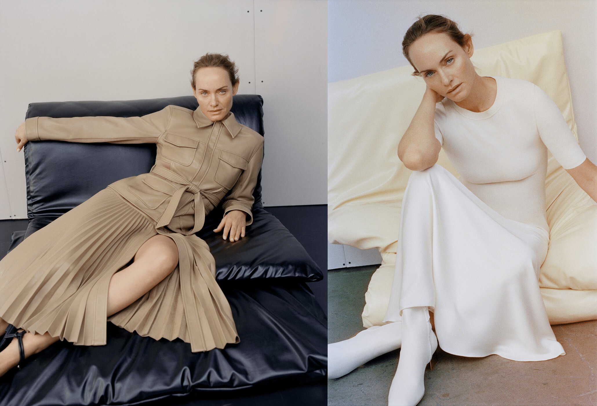 Fashion shot of a woman in a tan dress seated on a black cushion and a woman in a white dress and boots seated on a cushion.