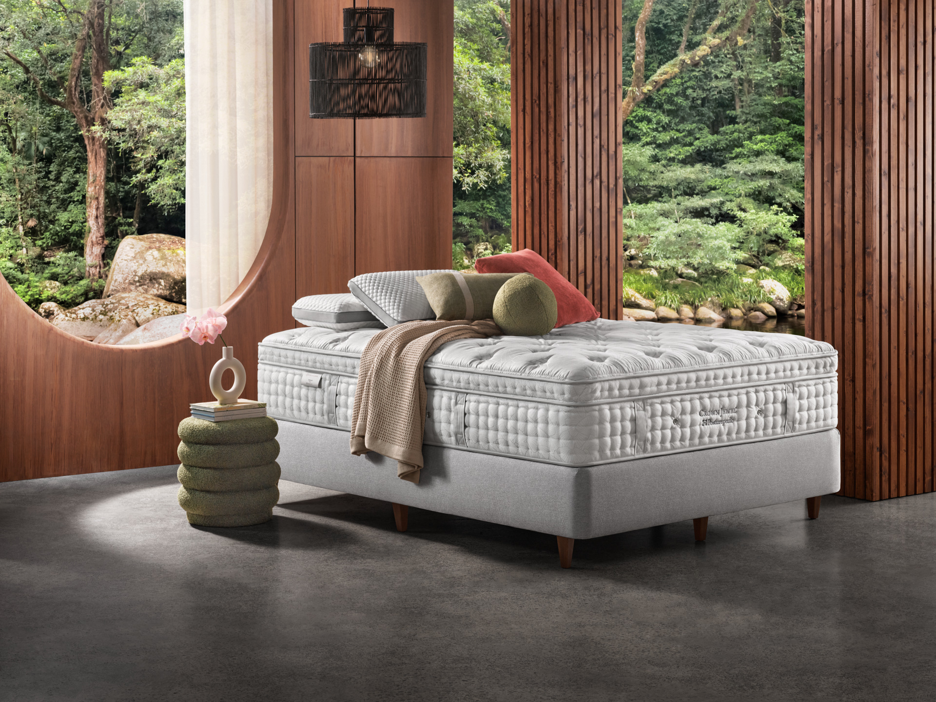 Elegant bedroom interior featuring a luxurious bed with pillows and a throw, alongside a stylish side table with decorative objects.