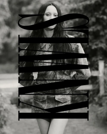 Black and white portrait of a person with long dark hair wearing a matching denim set, partially obscured by large black typography overlay.